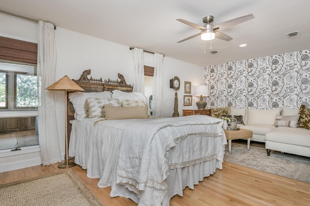 bedroom with light wood-style flooring, visible vents, and ceiling fan