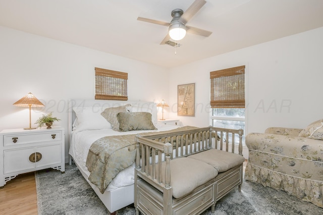 bedroom with wood finished floors, ceiling fan, and visible vents