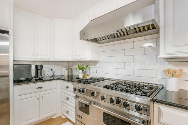 kitchen featuring range hood, white cabinetry, backsplash, and high quality appliances