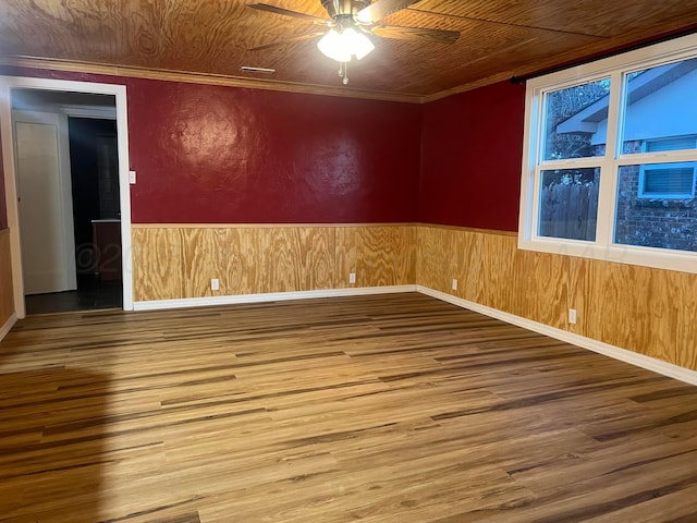 505 S Denton St, Booker, TX 79005 - empty room with wood finished floors, ceiling fan, wainscoting, crown molding, and wood walls