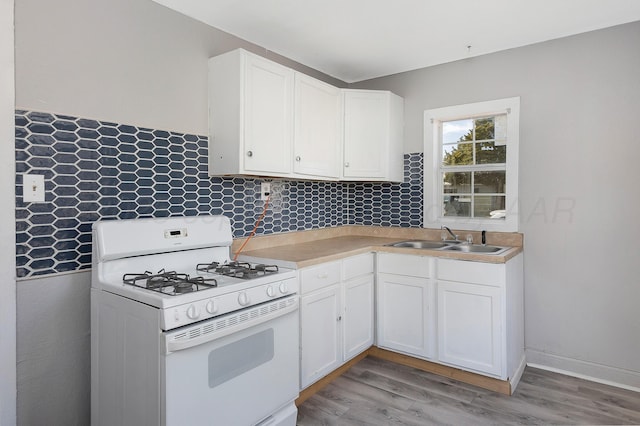 420 N Nelson St, Pampa, TX 79065 - kitchen with white cabinetry, light countertops, a sink, light wood-style floors, and white range with gas stovetop