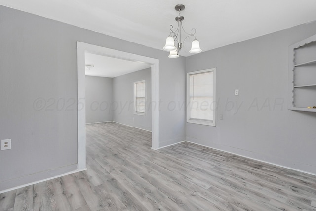 420 N Nelson St, Pampa, TX 79065 - empty room with baseboards, a notable chandelier, and light wood-type flooring