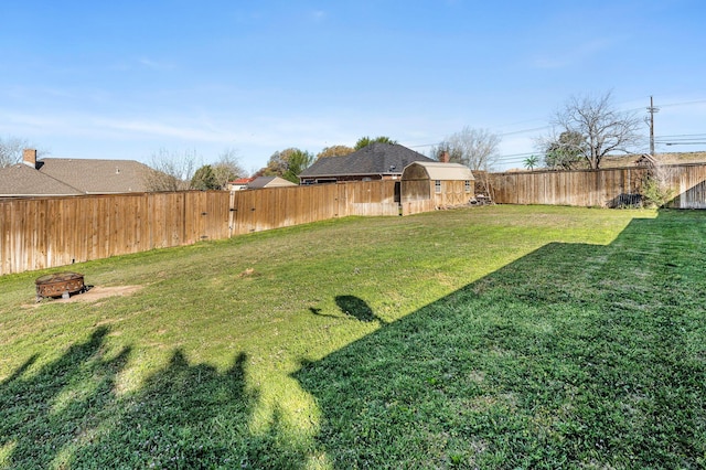 view of yard with an outdoor fire pit and a fenced backyard