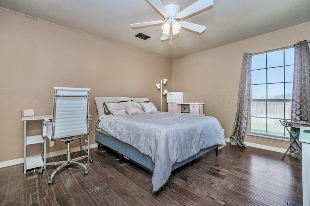 bedroom with visible vents, baseboards, a ceiling fan, and wood finished floors