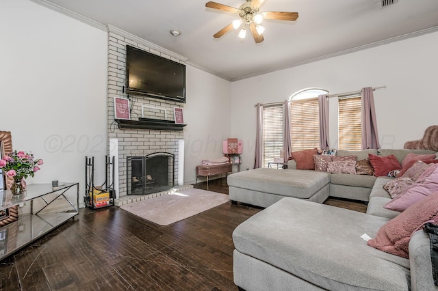 living area with visible vents, ceiling fan, a fireplace, crown molding, and wood finished floors