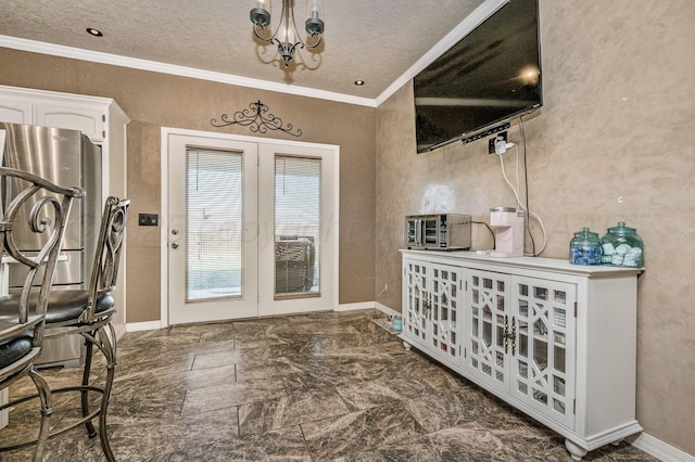 entrance foyer featuring baseboards, an inviting chandelier, crown molding, and a textured ceiling