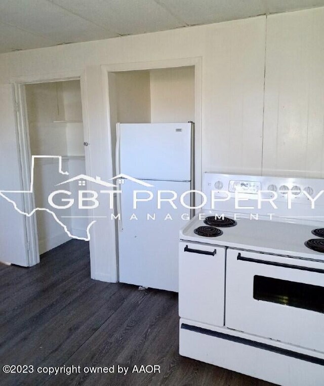 kitchen with white appliances and dark hardwood / wood-style floors