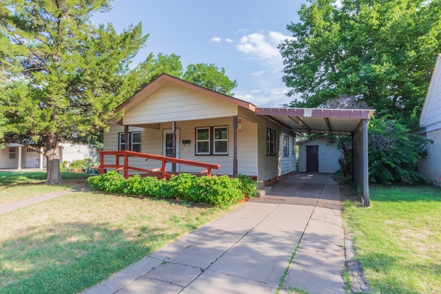 view of front of house featuring a carport, a garage, an outdoor structure, covered porch, and a front lawn