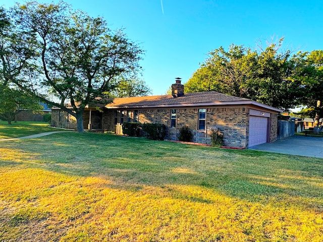 ranch-style house featuring a garage and a front lawn