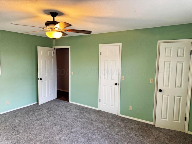 unfurnished bedroom featuring a textured ceiling, dark colored carpet, and ceiling fan