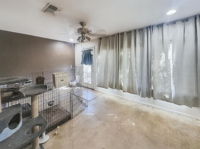 interior space with concrete floors, visible vents, and a ceiling fan