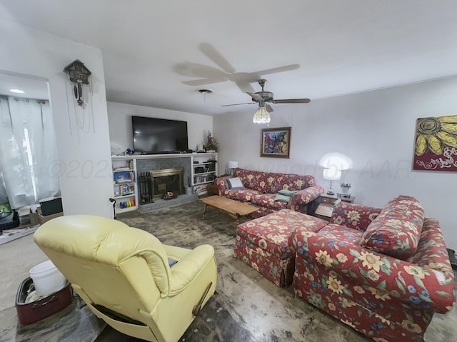 living area featuring a fireplace with raised hearth and a ceiling fan