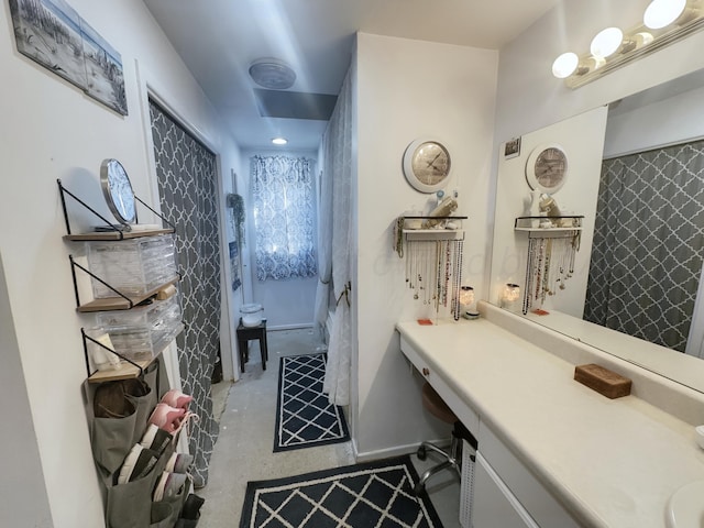 bathroom with concrete flooring, walk in shower, and vanity