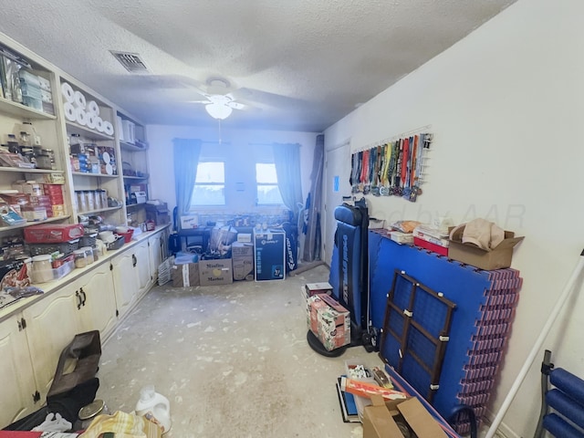 interior space with ceiling fan, concrete floors, visible vents, and a textured ceiling