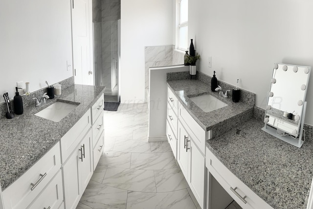 kitchen featuring dark stone countertops, white cabinetry, and sink