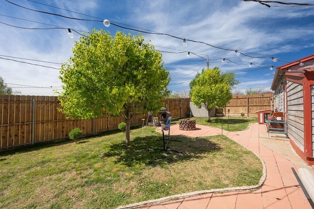 view of yard with a fenced backyard, a patio area, and an outdoor fire pit