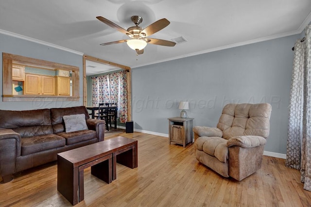 living area with light wood finished floors, visible vents, a ceiling fan, ornamental molding, and baseboards