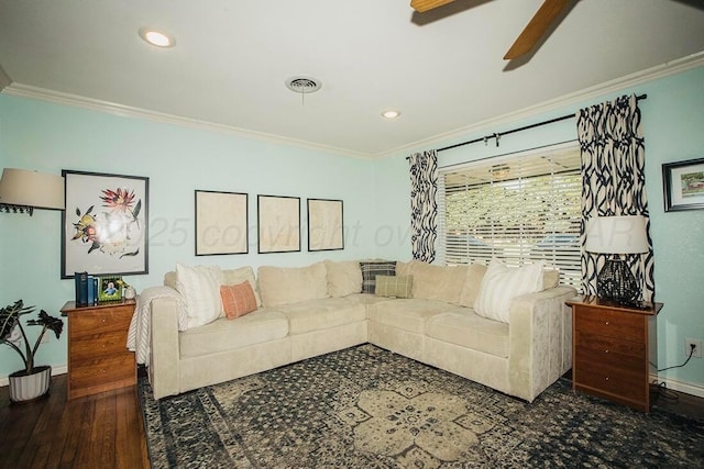 living room with a ceiling fan, baseboards, and ornamental molding