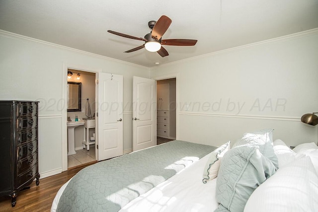 bedroom featuring connected bathroom, ceiling fan, ornamental molding, and wood finished floors