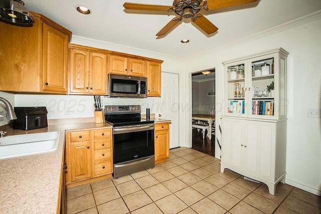 kitchen featuring a ceiling fan, a sink, light countertops, light tile patterned floors, and stainless steel appliances