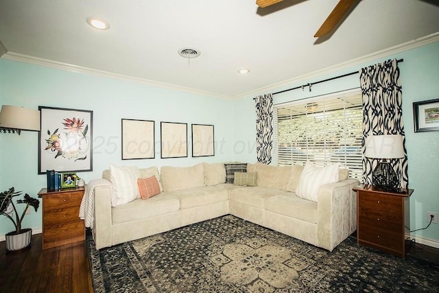 living room with crown molding, ceiling fan, visible vents, and baseboards