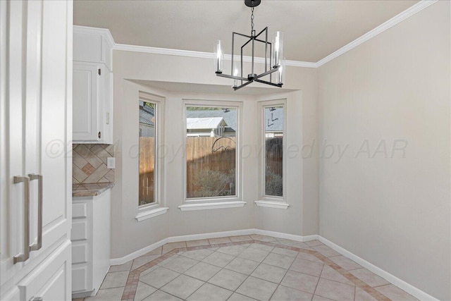 unfurnished dining area with light tile patterned floors, baseboards, ornamental molding, and a notable chandelier