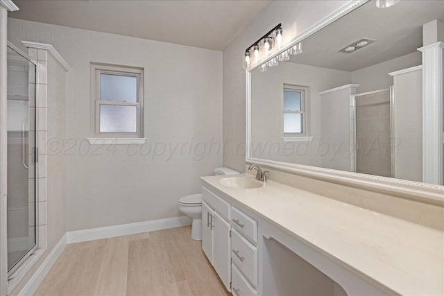 full bathroom with vanity, toilet, wood finished floors, and a stall shower