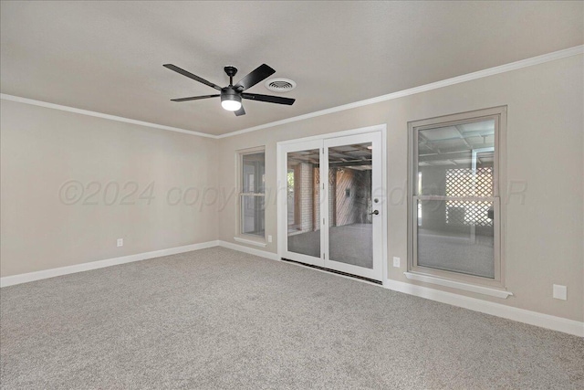spare room with visible vents, ornamental molding, baseboards, a ceiling fan, and carpet