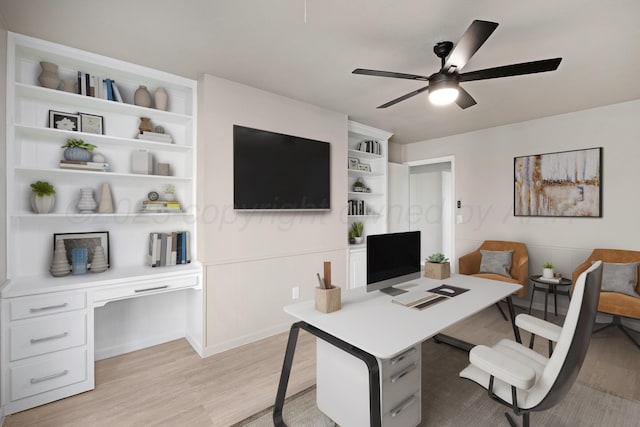 office area with light wood-style floors, ceiling fan, and built in shelves