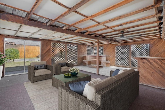 interior space featuring wooden walls, a ceiling fan, and carpet floors