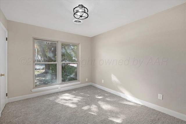 carpeted spare room with baseboards and visible vents