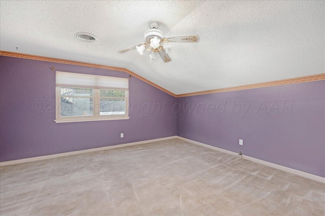 additional living space featuring visible vents, carpet floors, ceiling fan, a textured ceiling, and vaulted ceiling