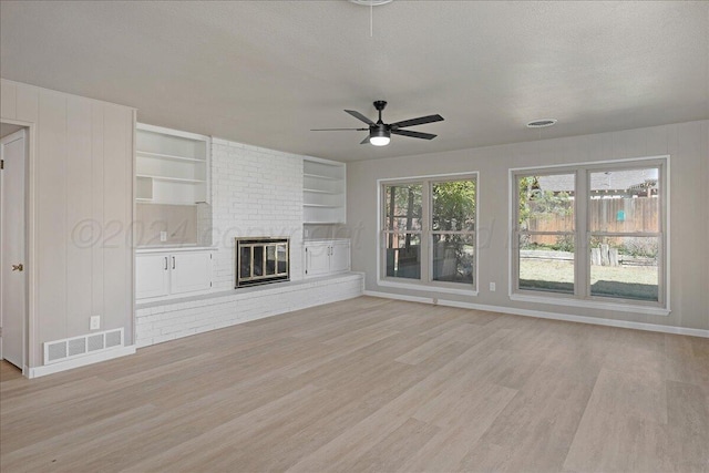 unfurnished living room featuring visible vents, light wood-style floors, ceiling fan, and baseboards