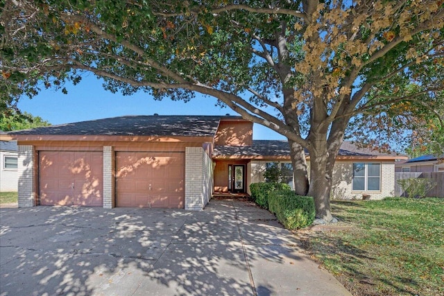 single story home with fence, a front lawn, brick siding, a garage, and concrete driveway