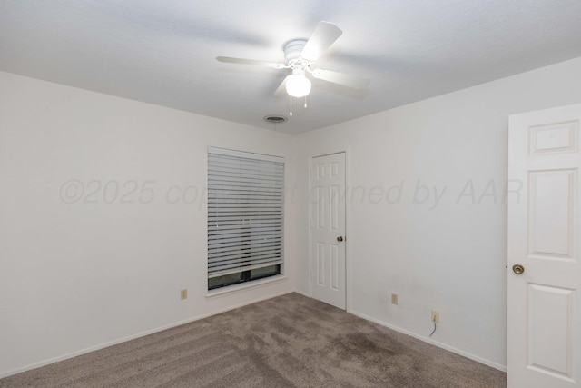 carpeted empty room with a ceiling fan and baseboards
