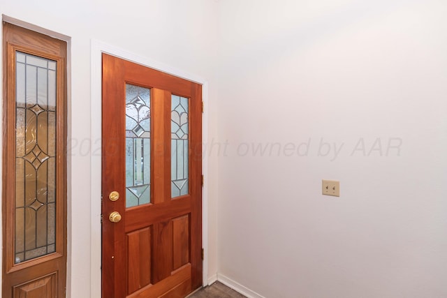foyer with baseboards and dark wood-style flooring