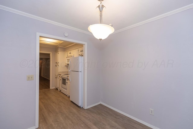 unfurnished dining area with crown molding, baseboards, and wood finished floors
