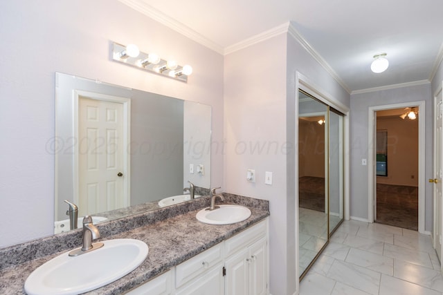 bathroom featuring marble look tiles, crown molding, and double vanity