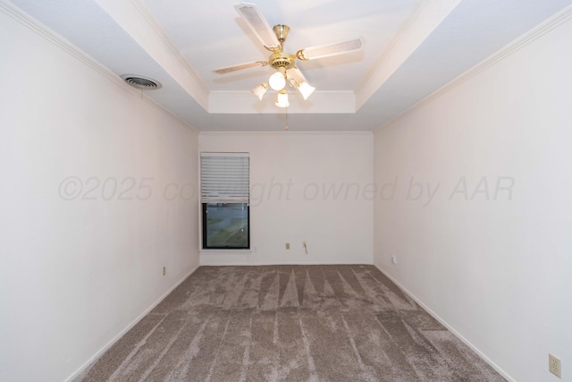 empty room featuring carpet, a raised ceiling, ornamental molding, ceiling fan, and baseboards