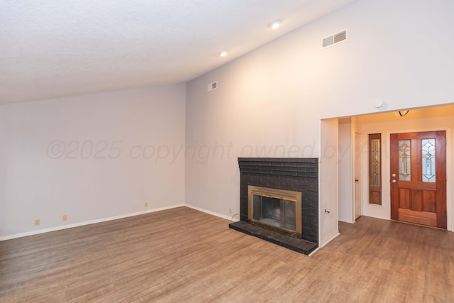 unfurnished living room featuring wood finished floors, a brick fireplace, baseboards, and recessed lighting
