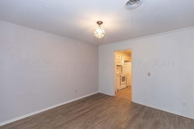 unfurnished room with wood finished floors, baseboards, and crown molding