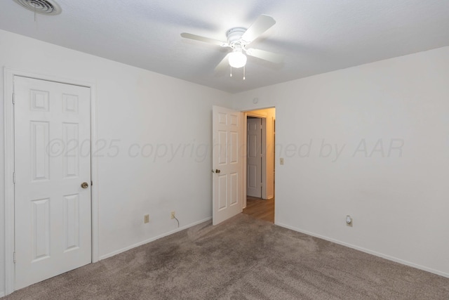 spare room featuring carpet, ceiling fan, and baseboards
