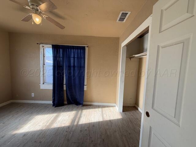 unfurnished bedroom with ceiling fan, hardwood / wood-style floors, and a closet