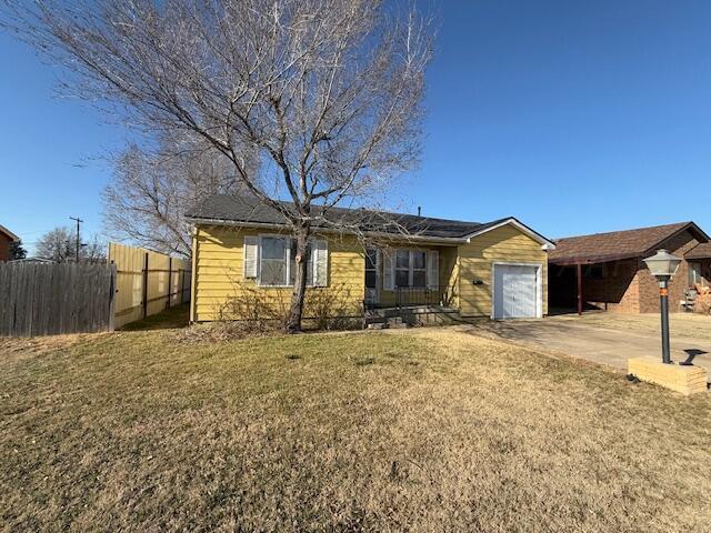 single story home featuring a garage and a front yard