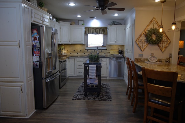 kitchen with white cabinetry, tasteful backsplash, decorative light fixtures, ornamental molding, and stainless steel appliances