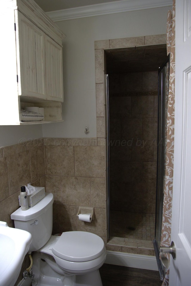 bathroom featuring crown molding, tile walls, an enclosed shower, vanity, and toilet