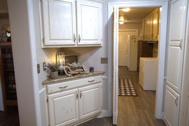 kitchen featuring white cabinetry, white fridge, dark wood-type flooring, and separate washer and dryer