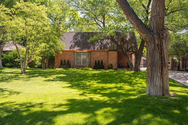 2411 S Lipscomb St, Amarillo, TX 79109 - view of front of home with a front yard, brick siding, and roof with shingles