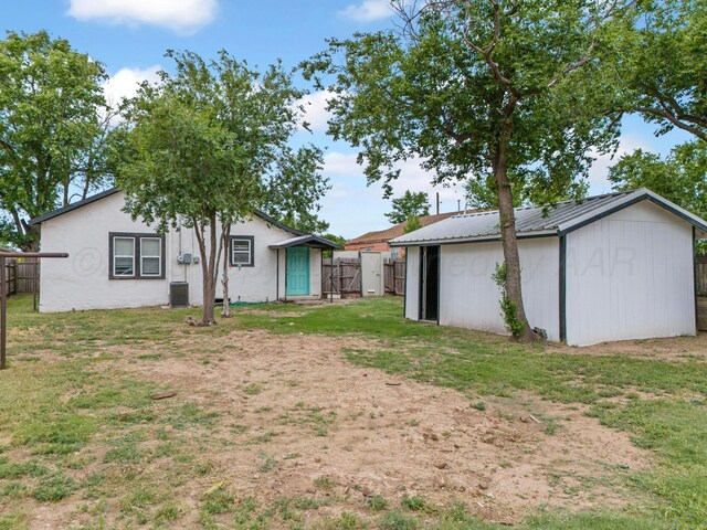 234 N Birge Ave, Dumas, TX 79029 - rear view of property with an outbuilding, metal roof, and cooling unit