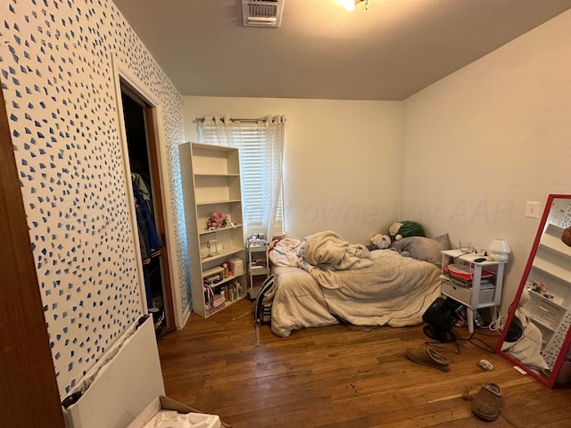 bedroom featuring visible vents and hardwood / wood-style flooring